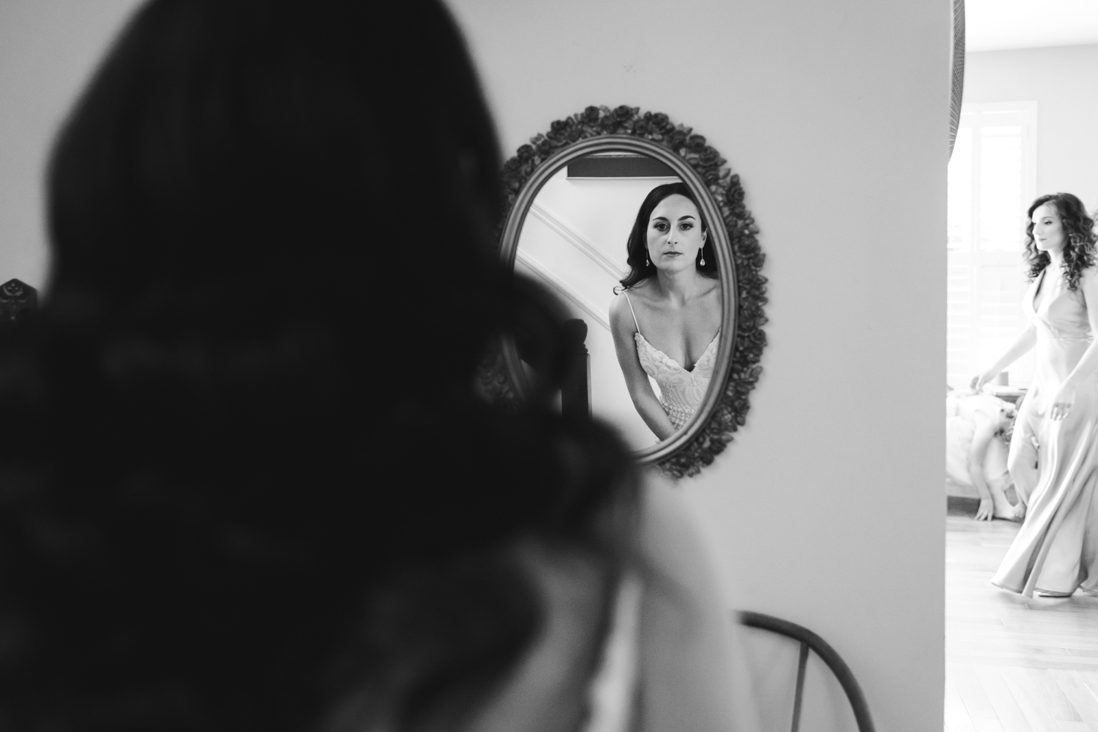 bride checking herself out in a vintage mirror in black and white