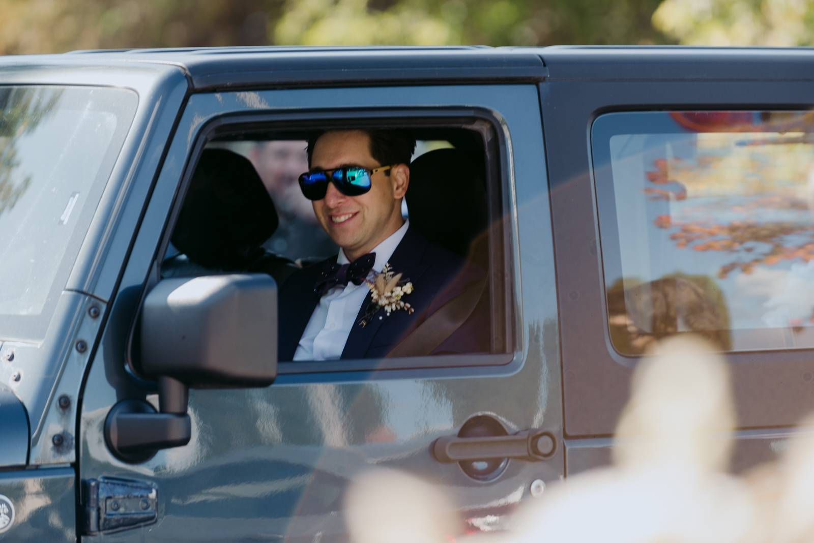 groom in old jeep wrangler with sunglasses on
