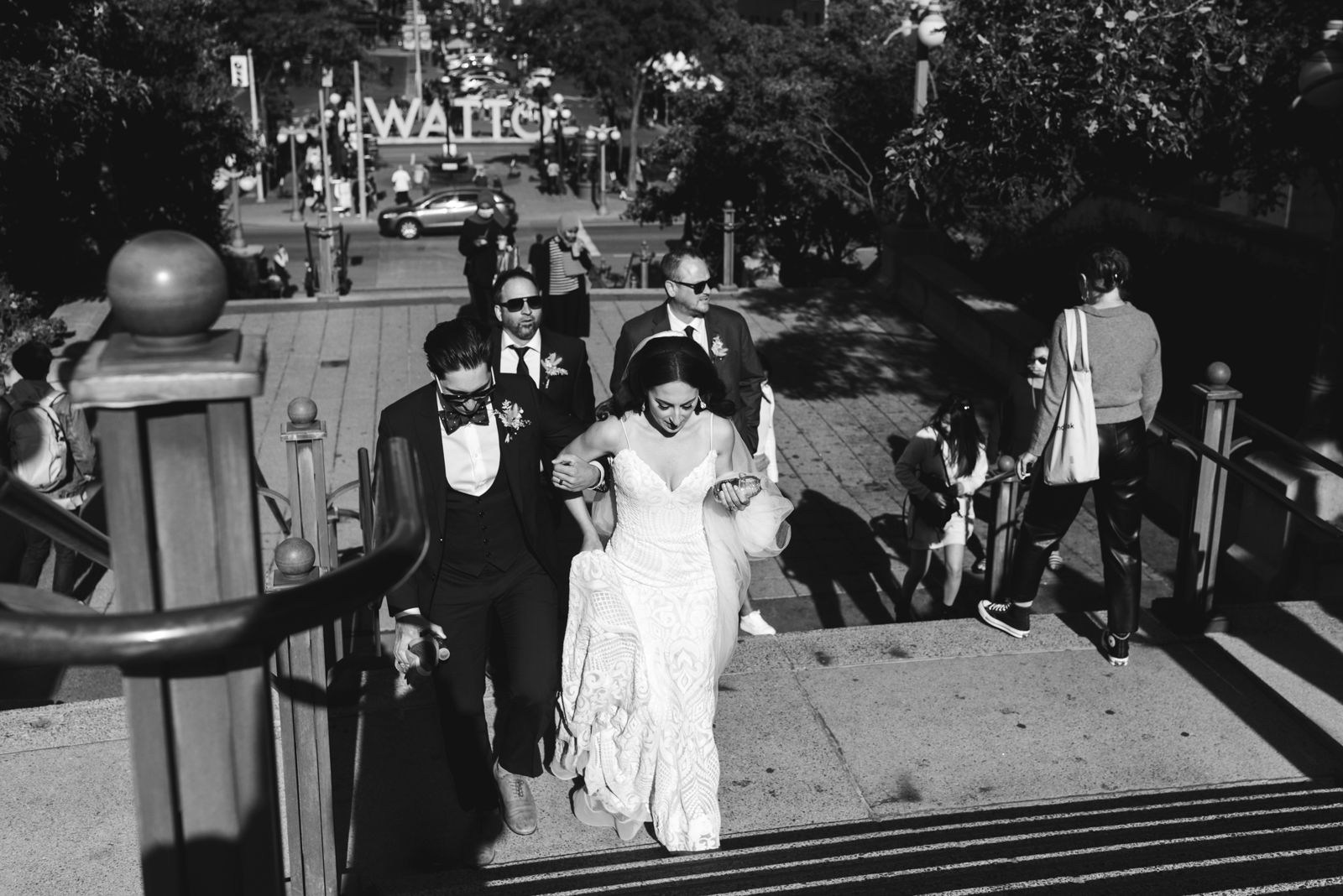 bride and groom walking up steps in byward market in black and white