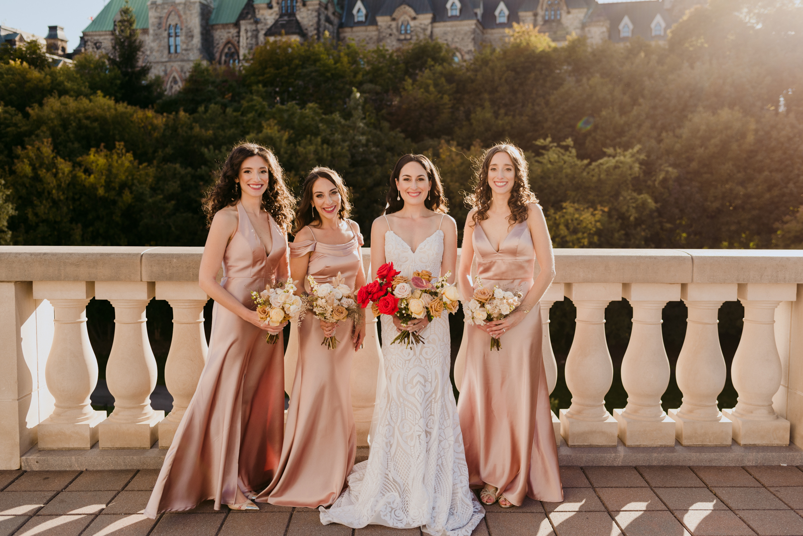 bride and bridesmaids on the terrace of the chateau laurier with parliament buildings in the background