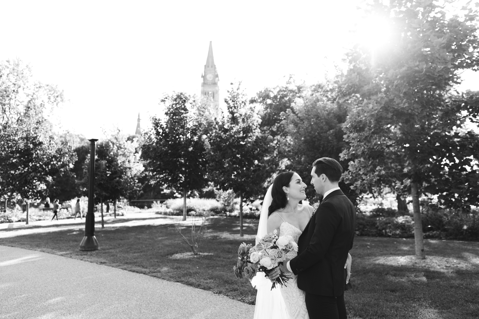 bride and groom in majors hill park with parliament in the background in black and white
