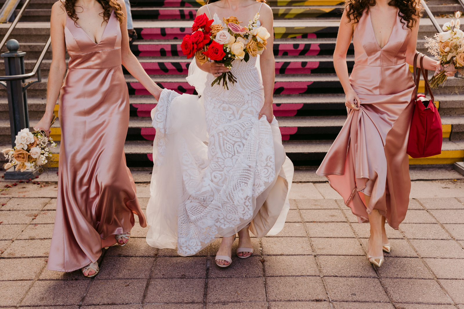 bride and bridesmaids walking down painted staircase in byward market at sunset