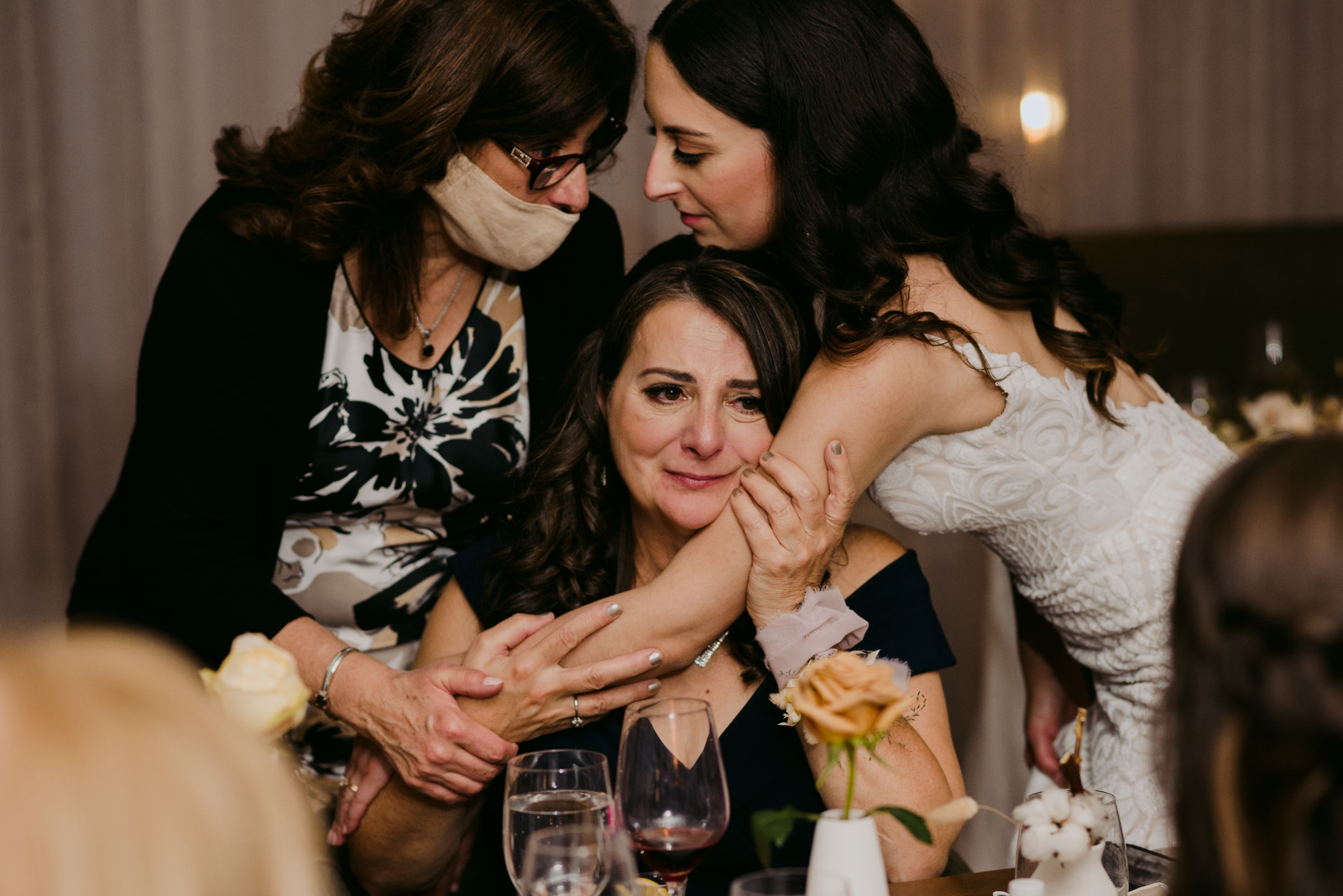 bride and aunt hugging mother of the bride as she cries