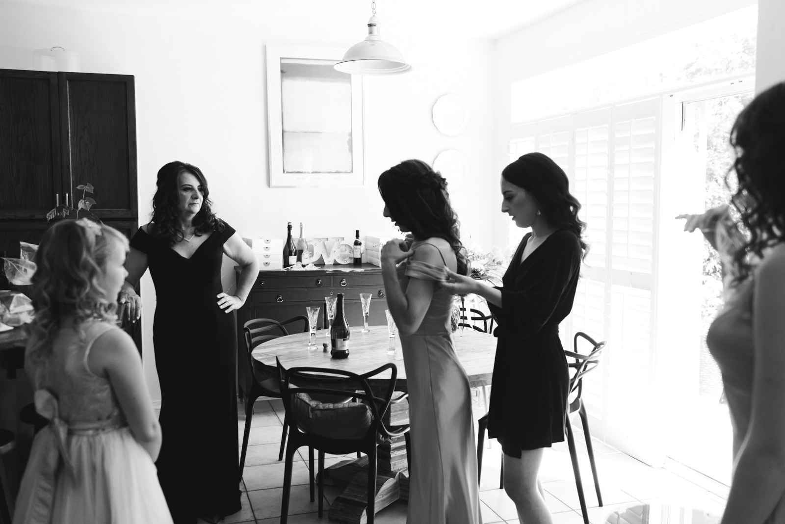 bride and bridesmaids getting ready in kitchen in black and white