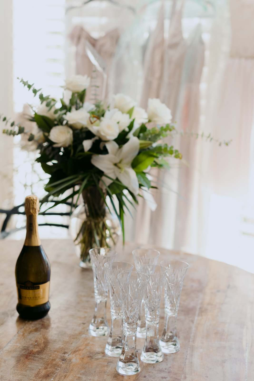 vintage champagne glasses on a table with flowers and champagne bottle