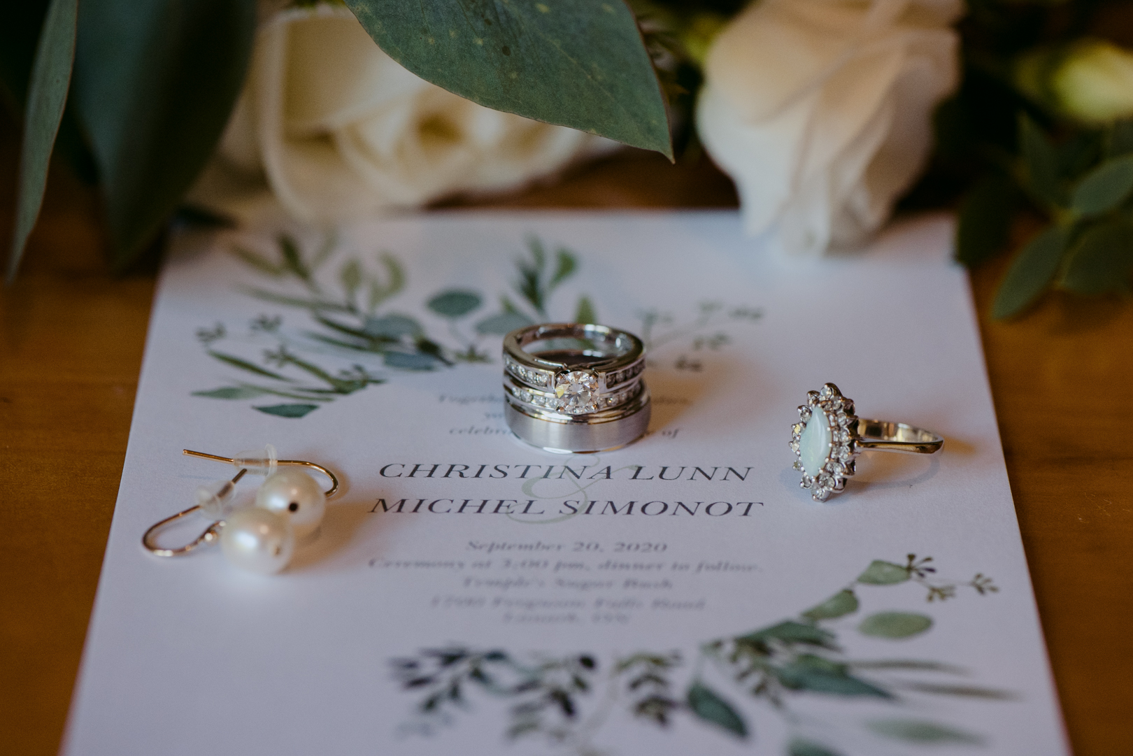 flat lay of wedding details including invitation and rings