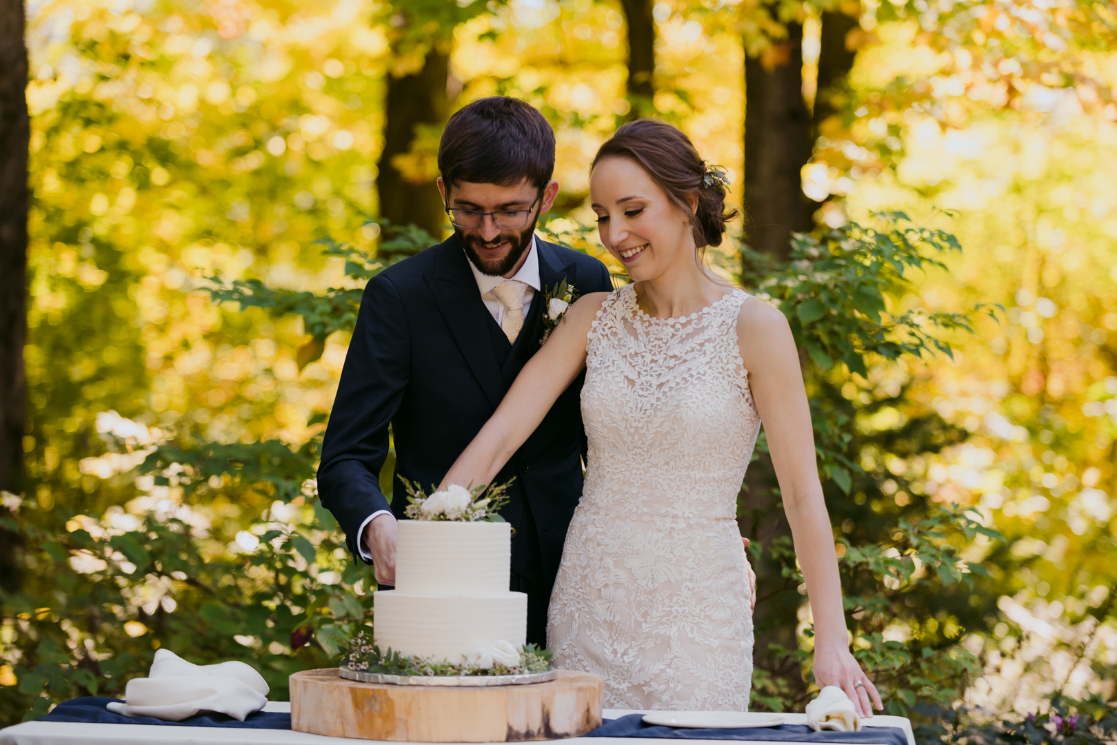 bride and groom cutting cake outside