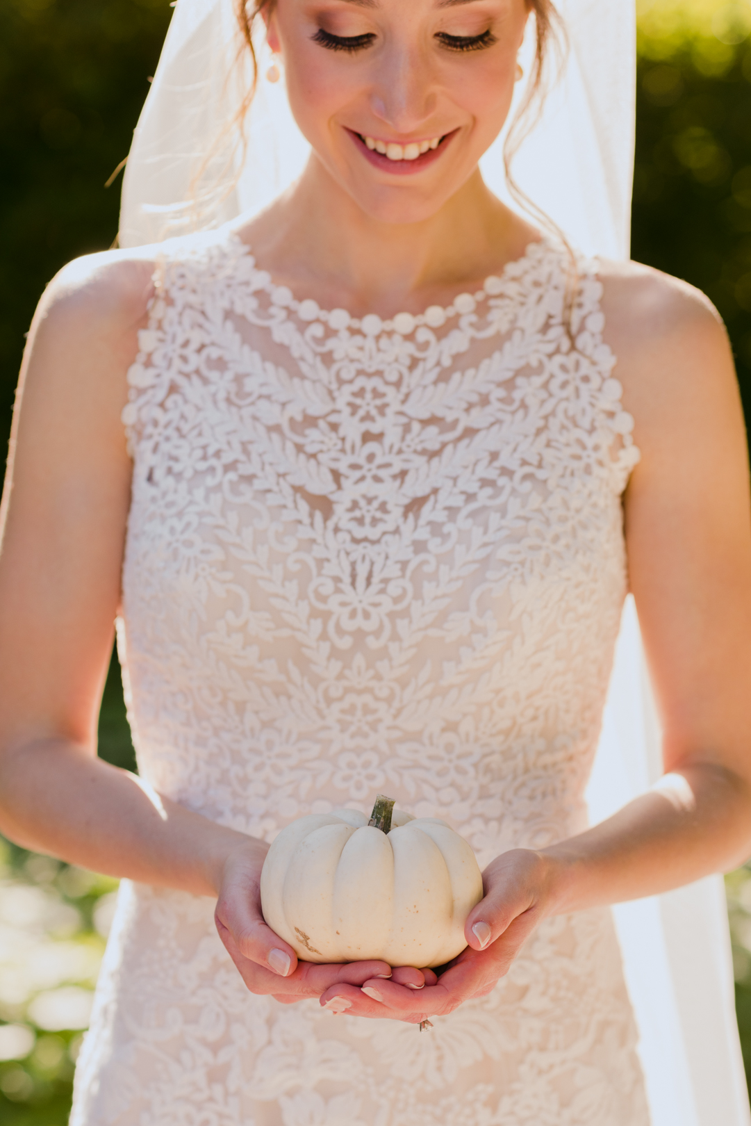 bride holding mini white pumpkin