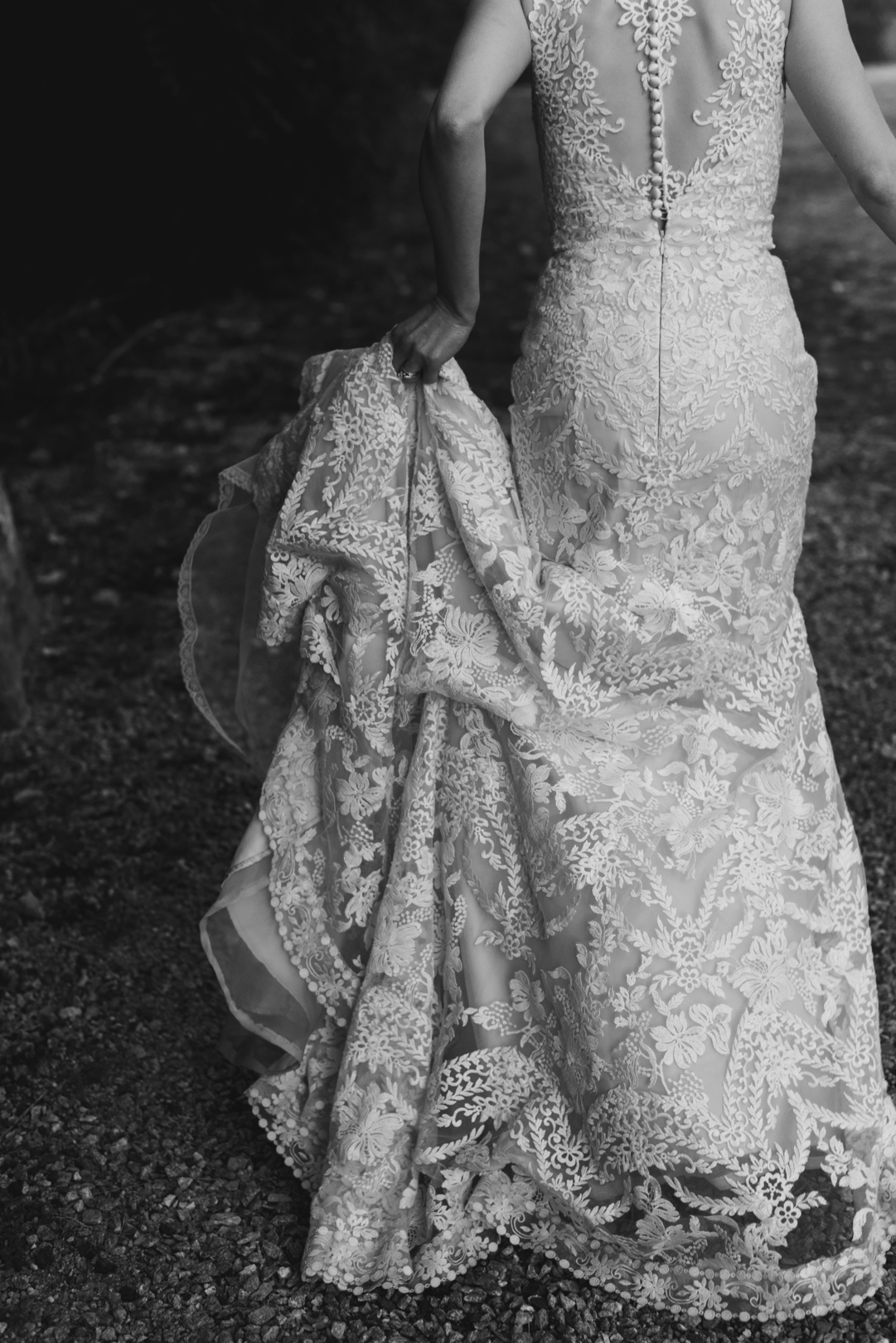 bride holding the train of her dress in black and white