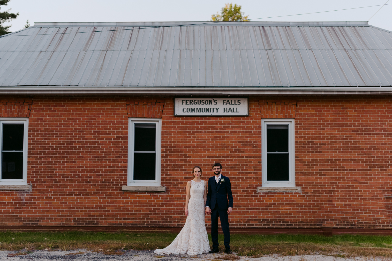 bride and groom in front of ferguson falls community hall