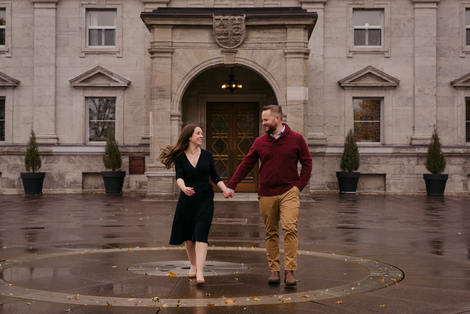 engaged couple running away from rideau hall doors