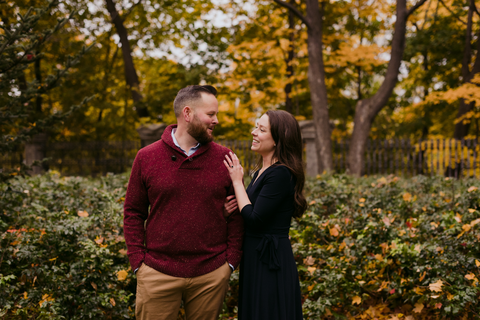 engaged couple laughing in the fall leaves