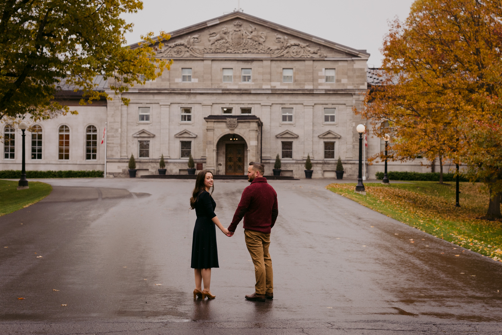 engaged couple holding hands outside rideau hall on a fall day