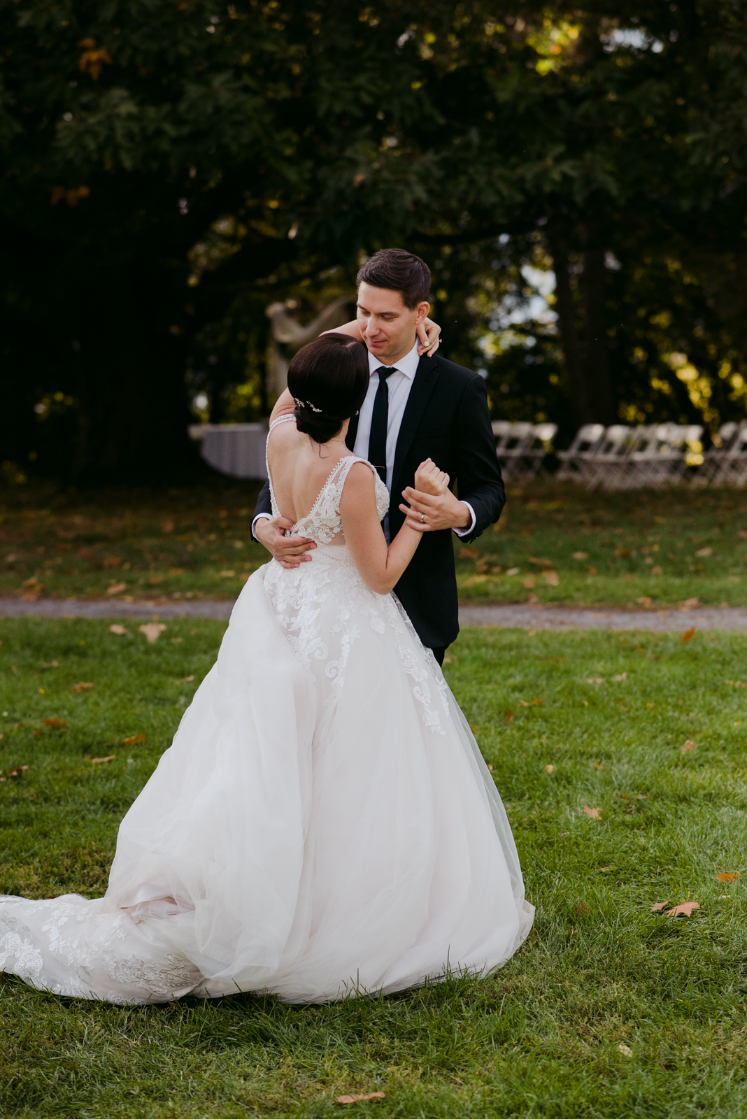 bride and groom first dance outdoors on the grass of garden party wedding