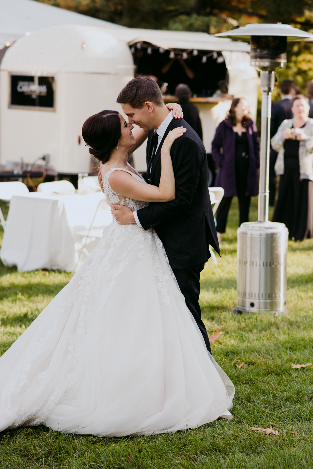 bride and groom first dance outdoors on the grass of garden party wedding