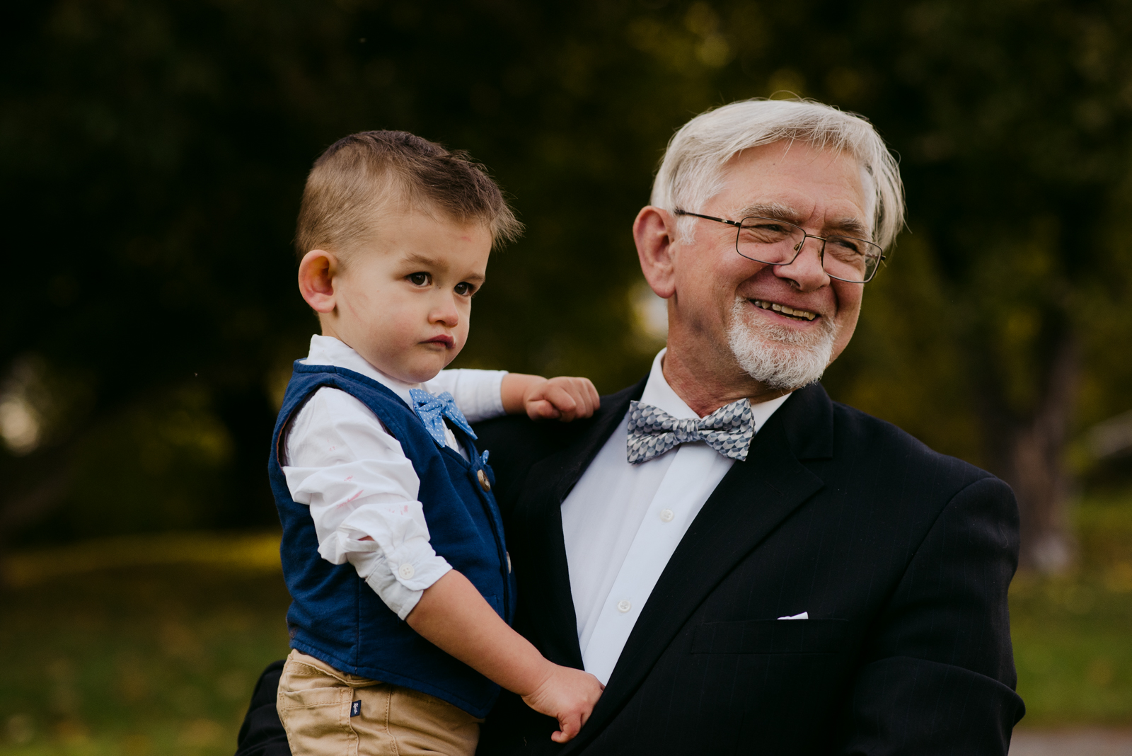 father of the groom and grandson smiling during outdoor reception