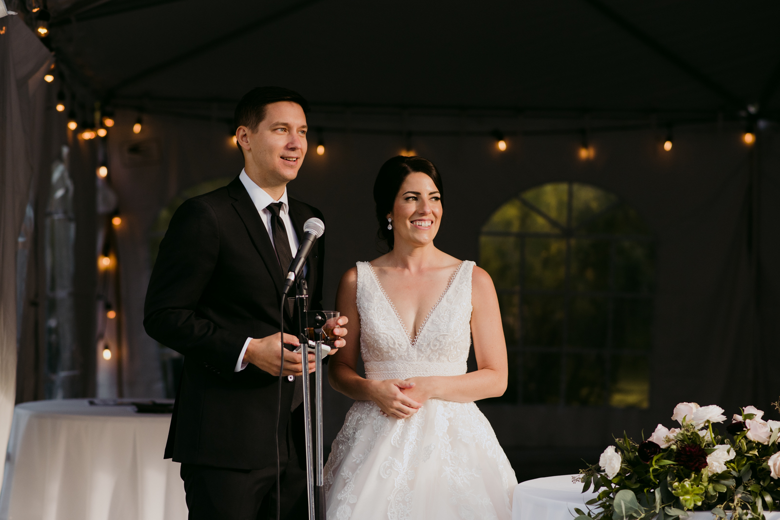 bride and groom giving speech during outdoor wedding reception