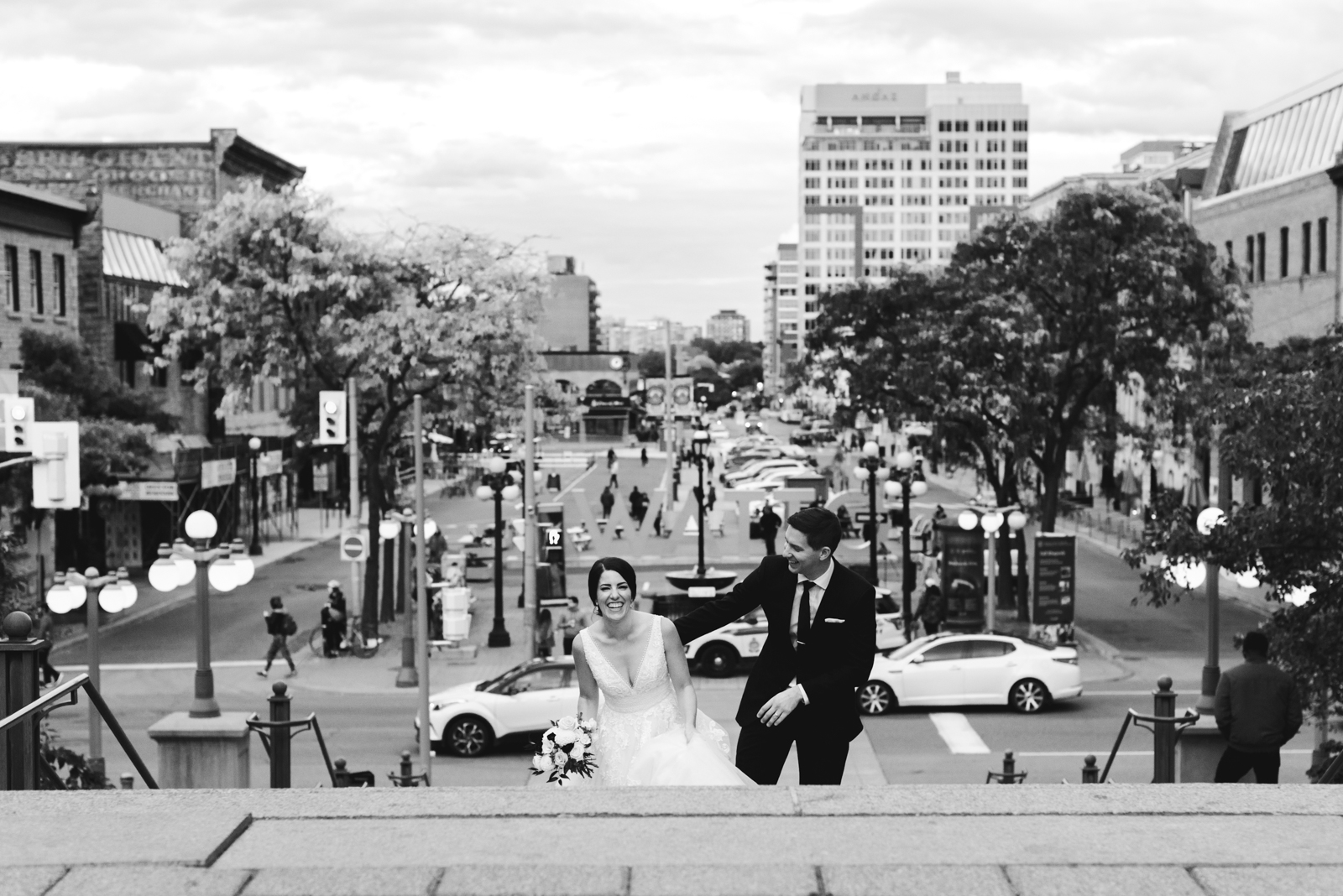 bride and groom walking up the steps with byward market in the background