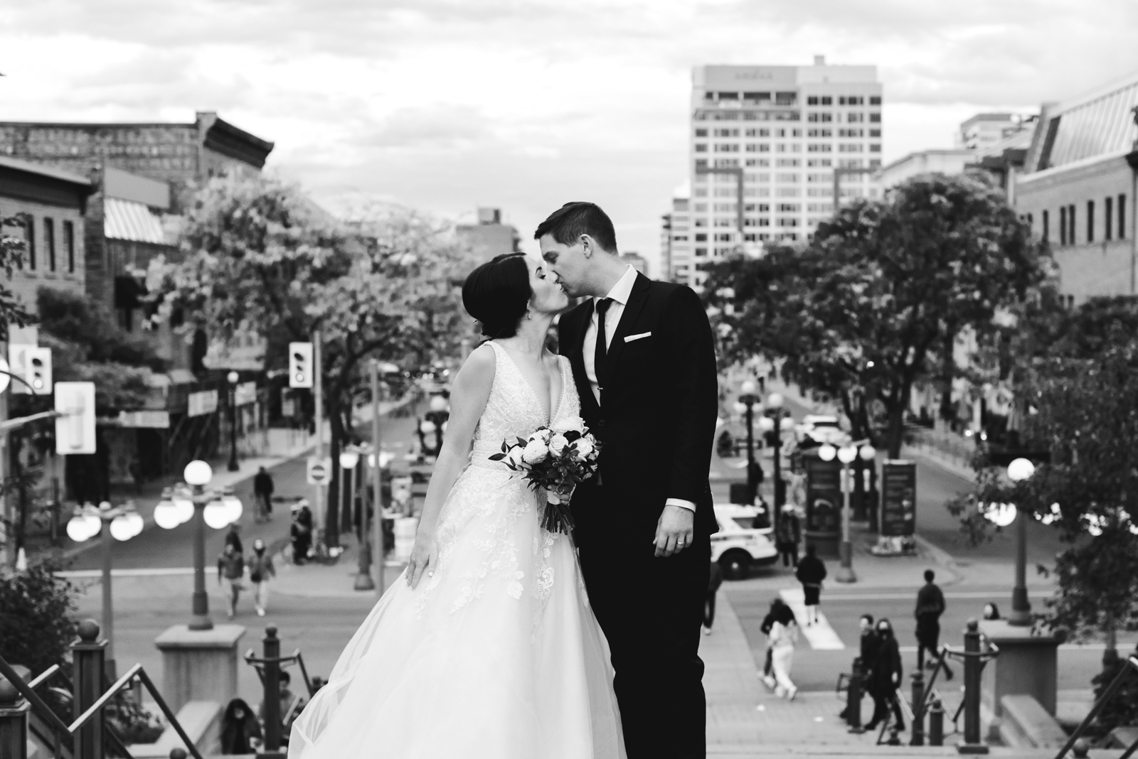 bride and groom kissing on steps with byward market in the background