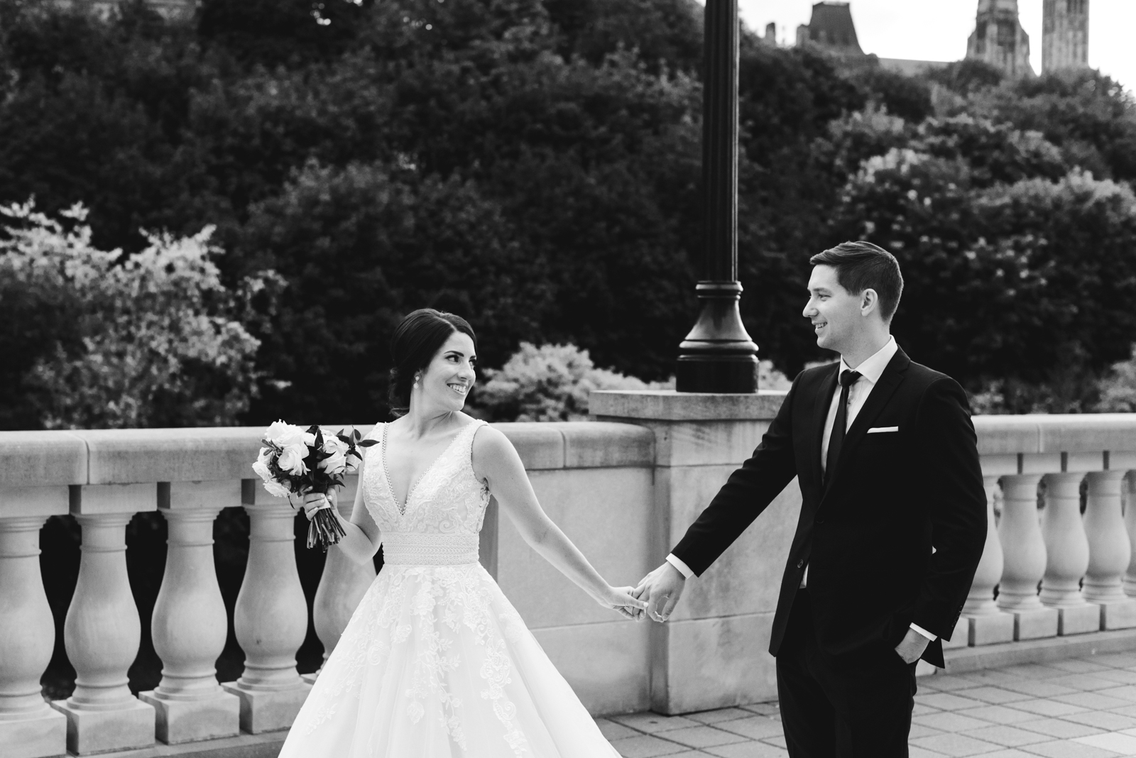 bride and groom holding hands along pavilion of chateau laurier