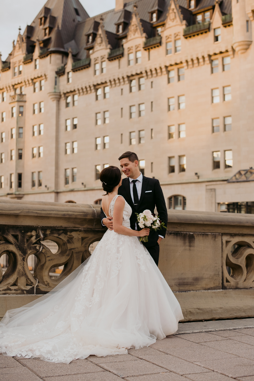 bride and groom by the chateau laurier at sunset