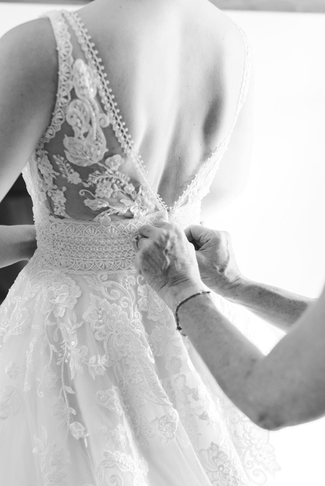 bride's mother tying up her dress in black and white