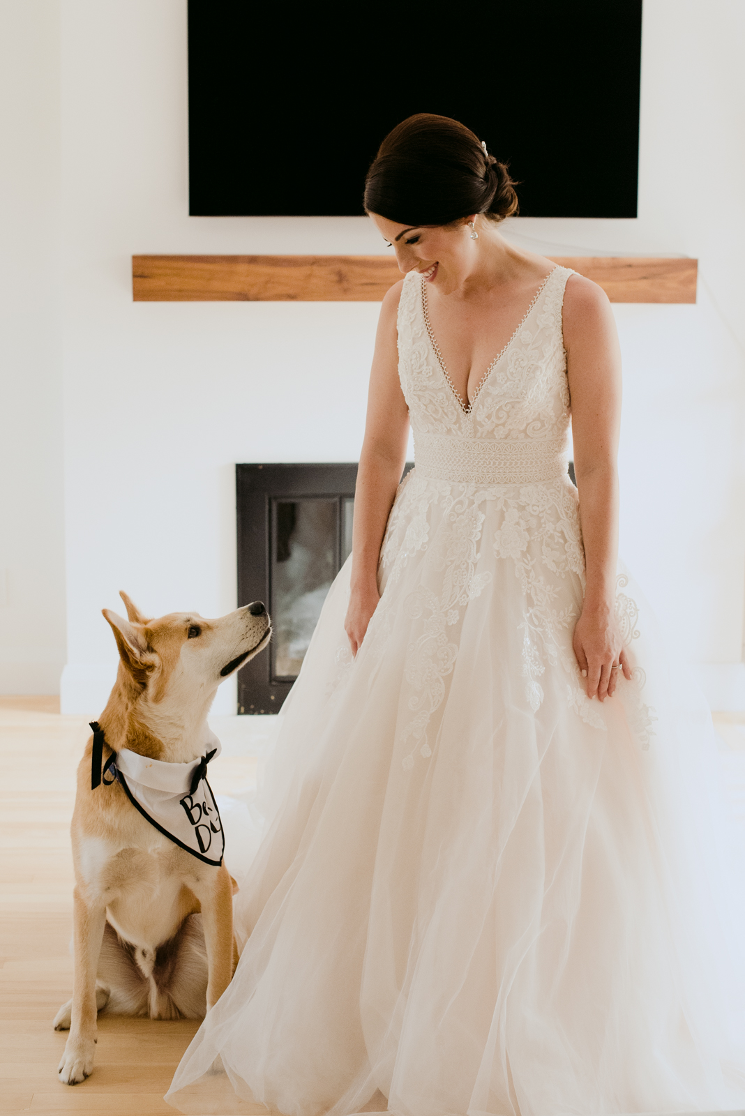 bride and her dog looking at each other smiling