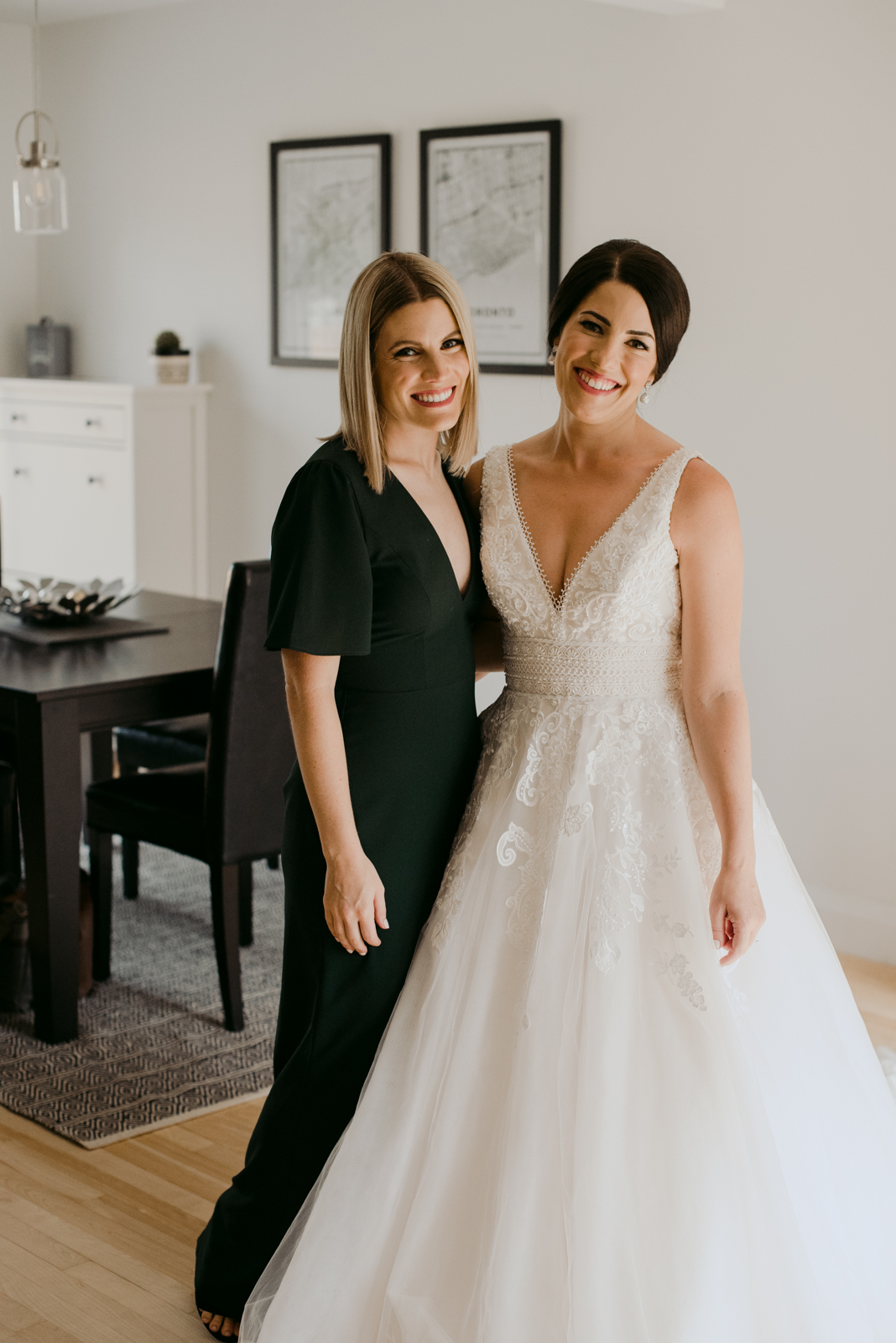 bride and her sister smiling at the camera while getting ready