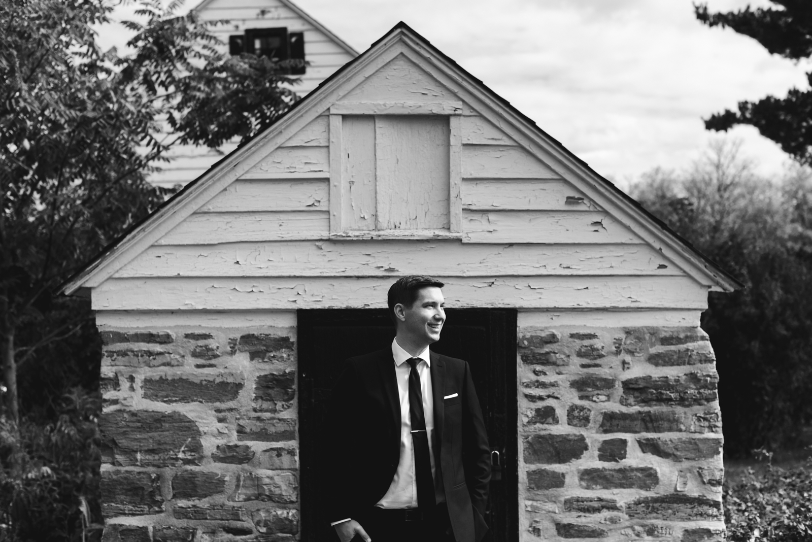 groom in front of cigar house in black and white