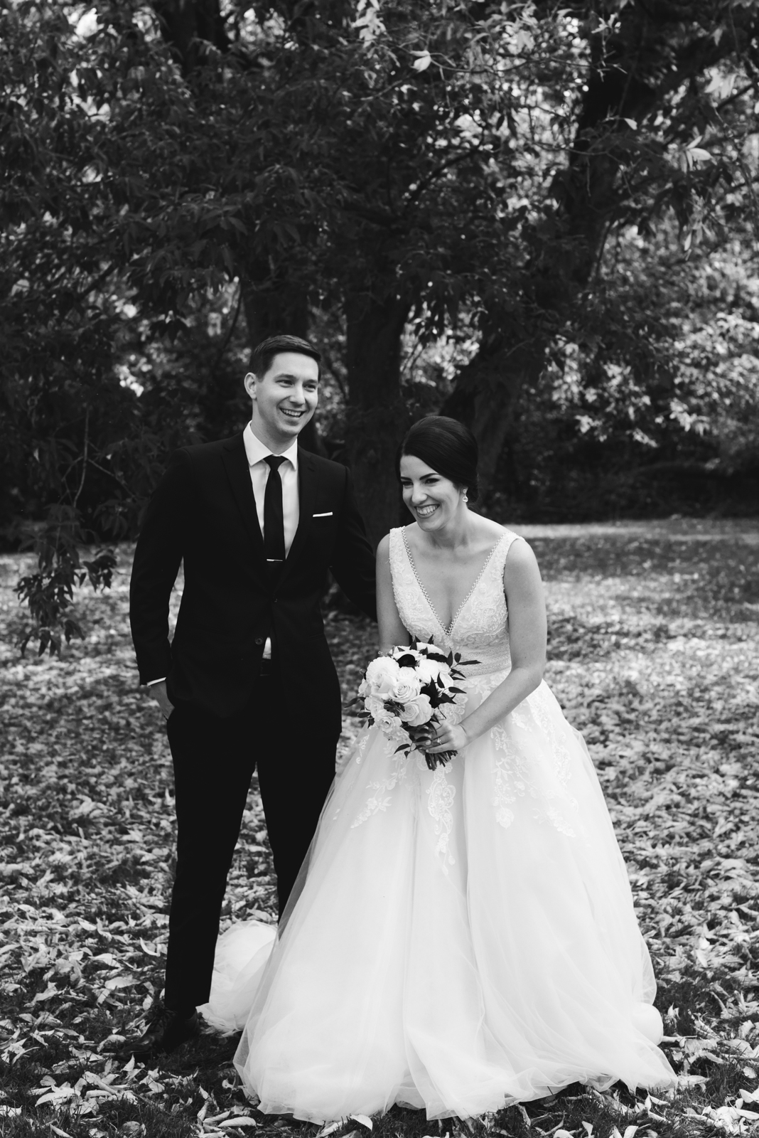 bride and groom laughing outdoors in black and white