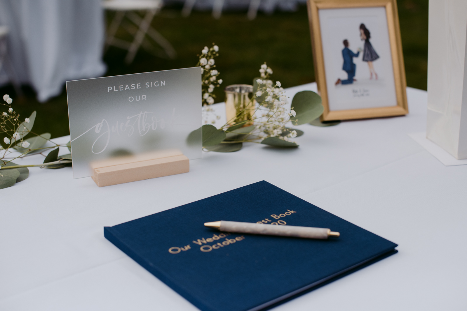 Wedding guest book on table at outdoor wedding reception