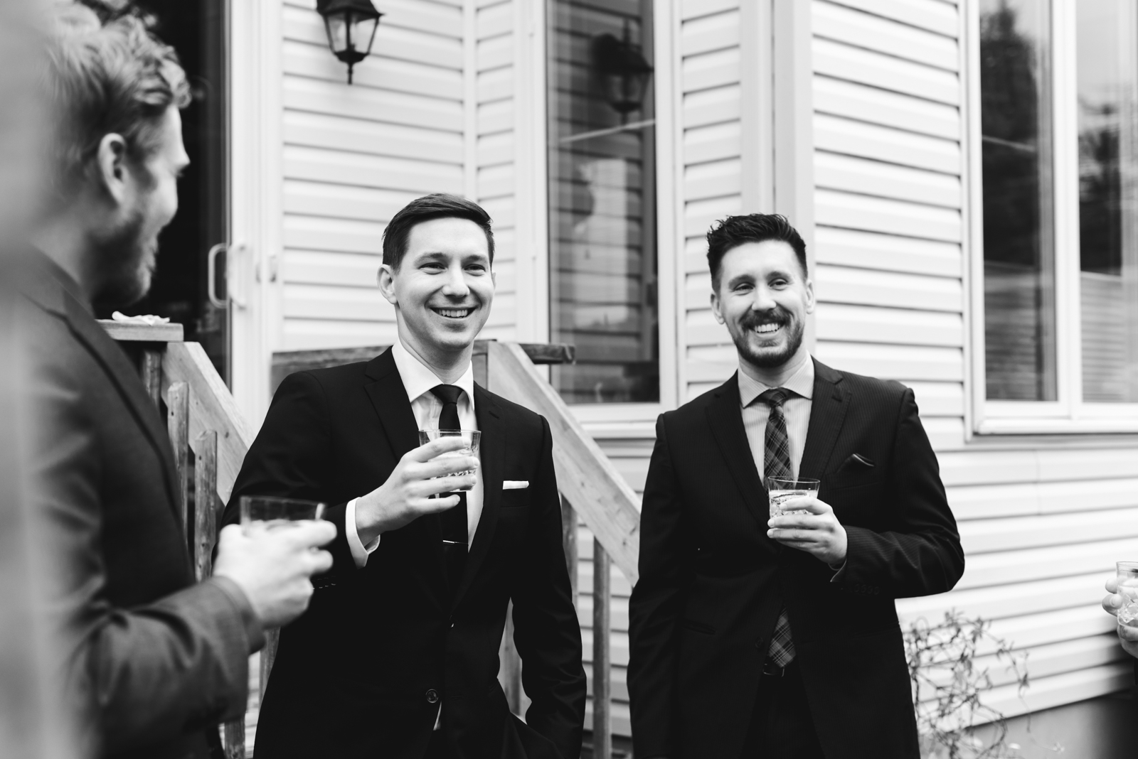 groom and groomsmen having a drink outside before ceremony laughing