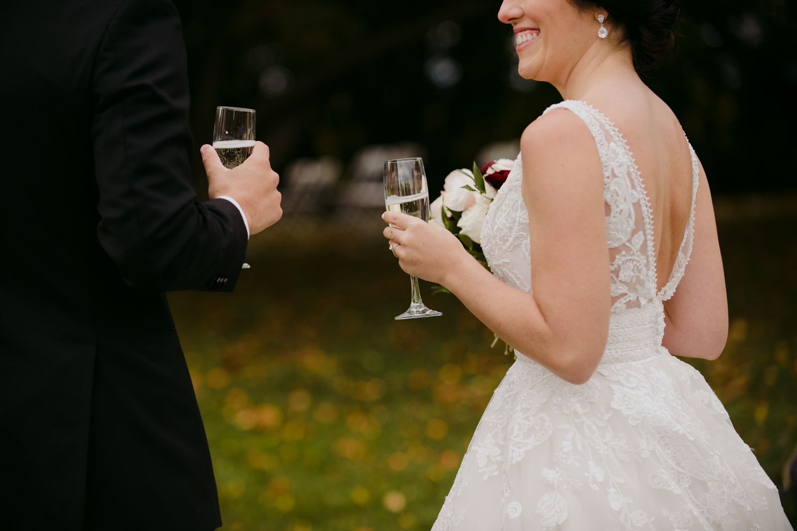 bride and groom holding champagne after wedding ceremony