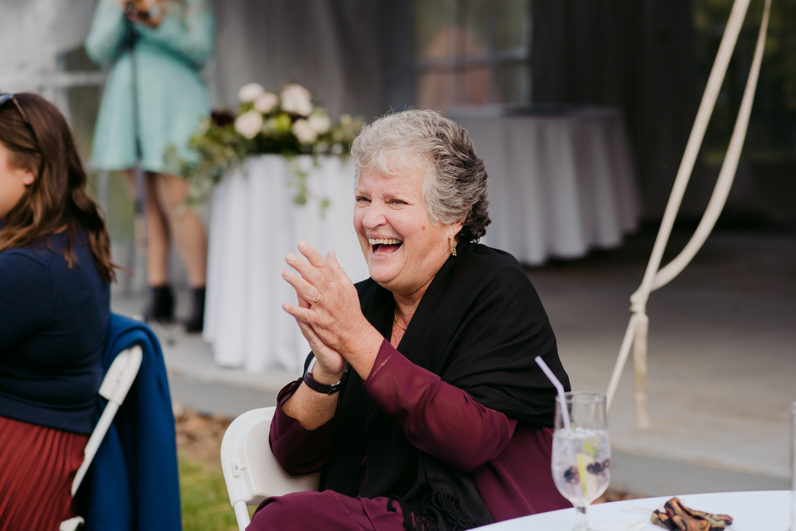 wedding guest laughing during speeches at outdoor wedding reception
