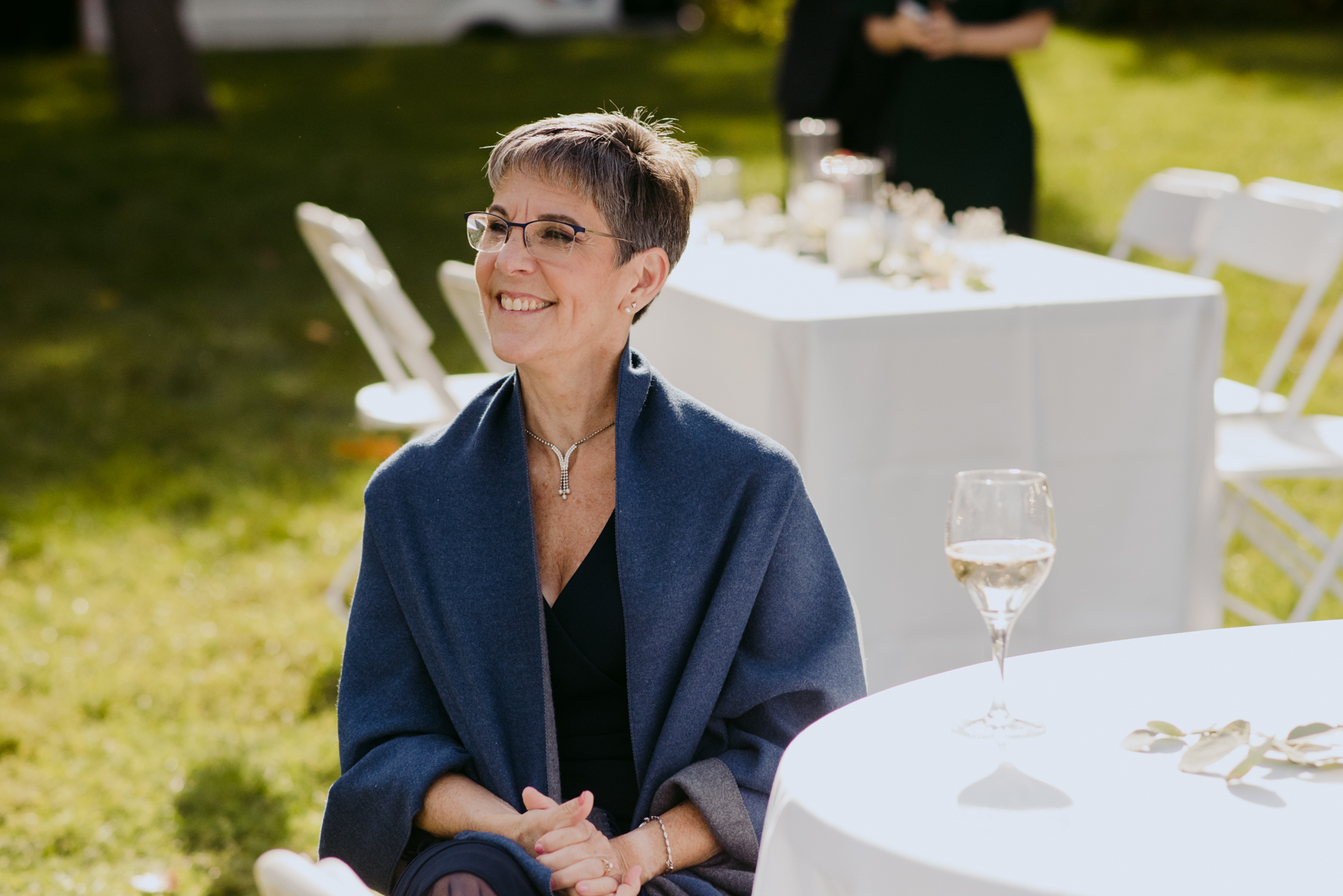mother of the bride smiling during speeches at outdoor wedding reception