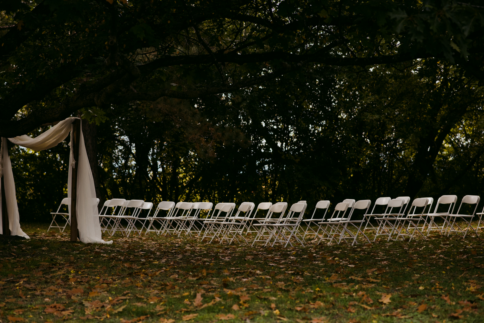 chairs set up in front of wooden arch at outdoor wedding ceremony at Billings Estate museum