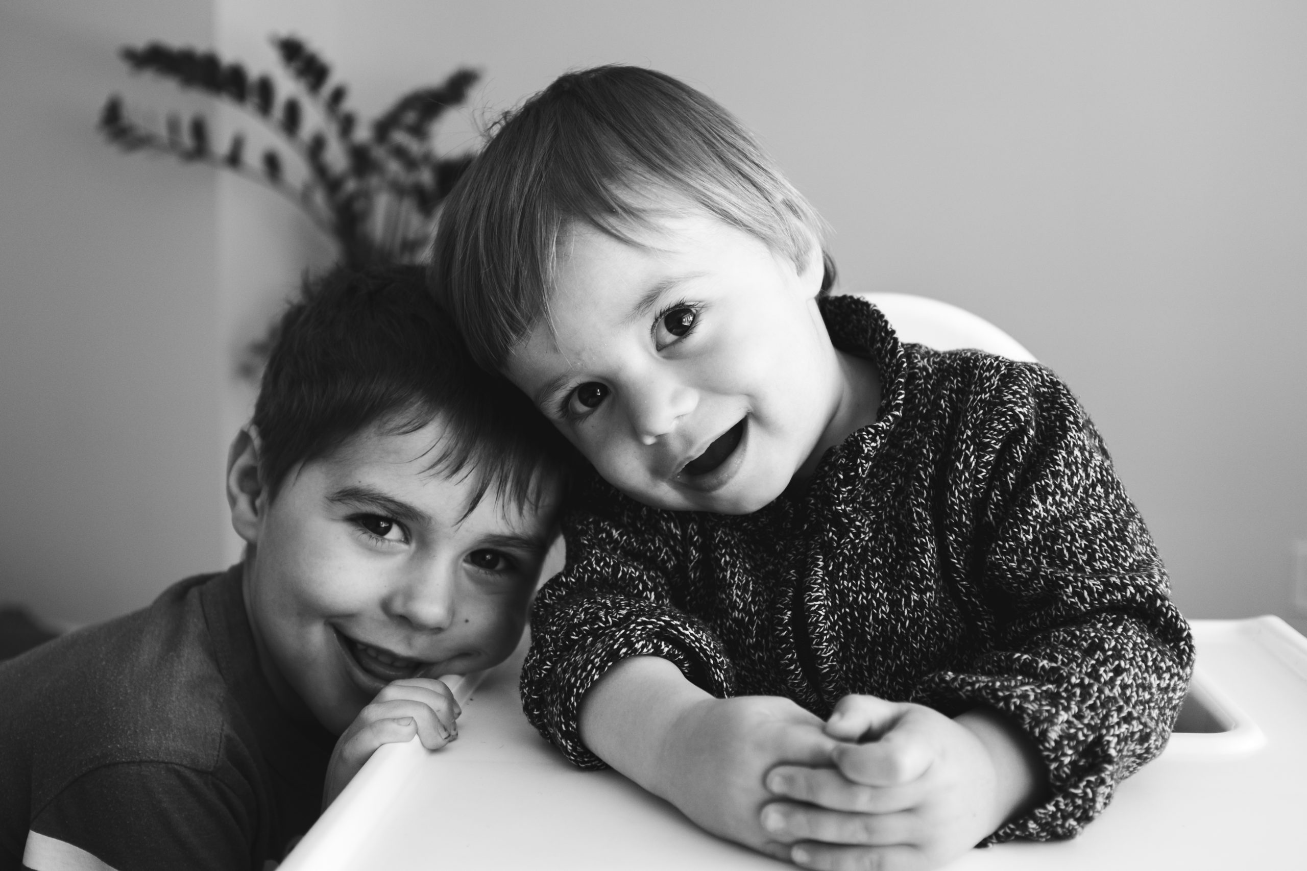 Two brothers smiling at the camera in black and white