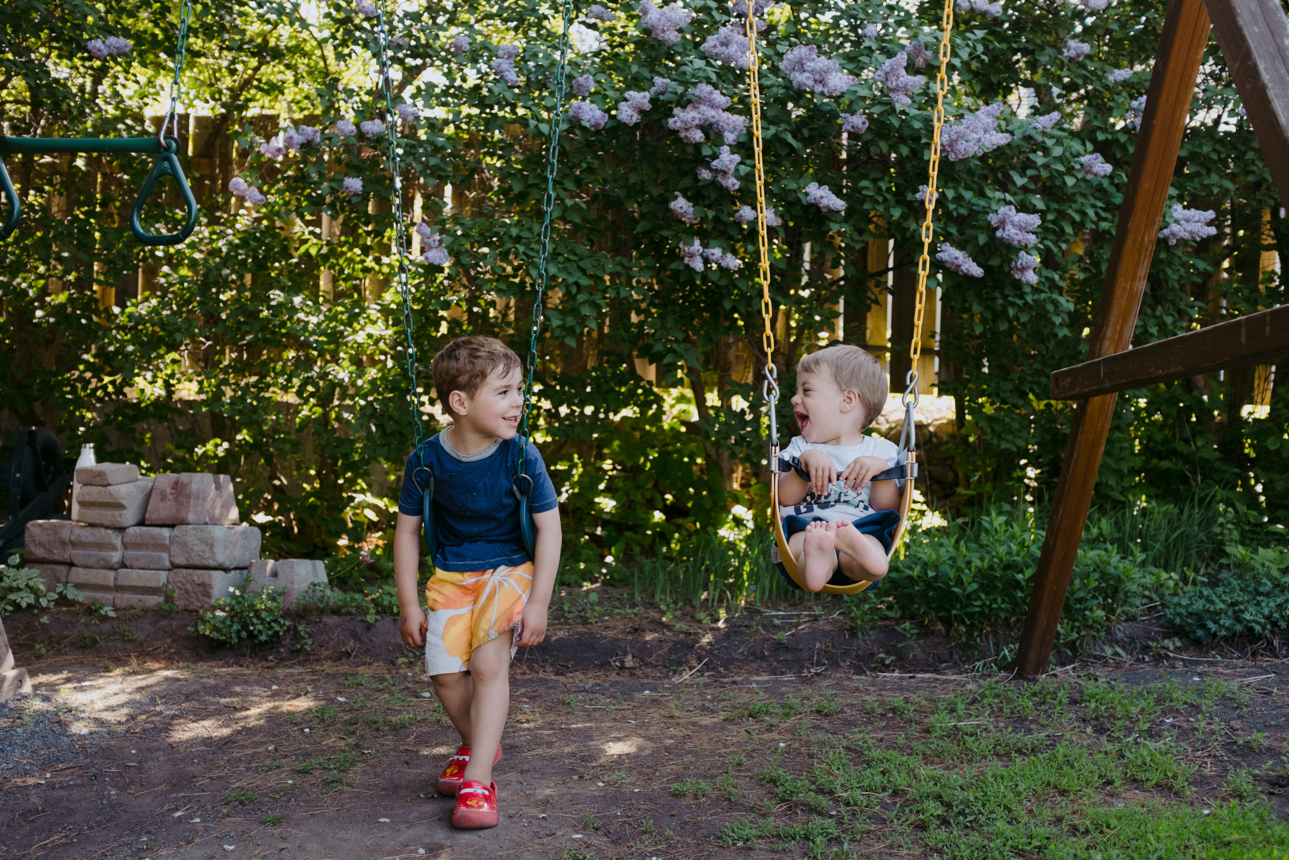 two brothers on swing set laughing