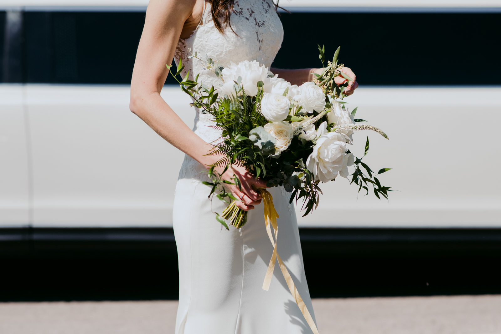 bride with her bouquet outside of limo
