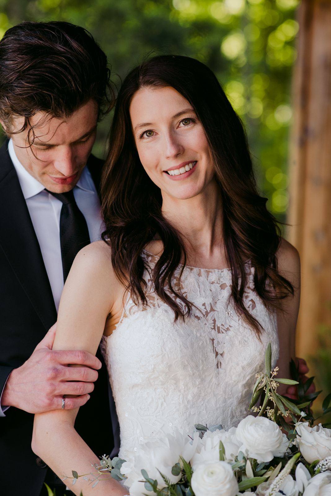 bride smiling at the camera holding white bouquet