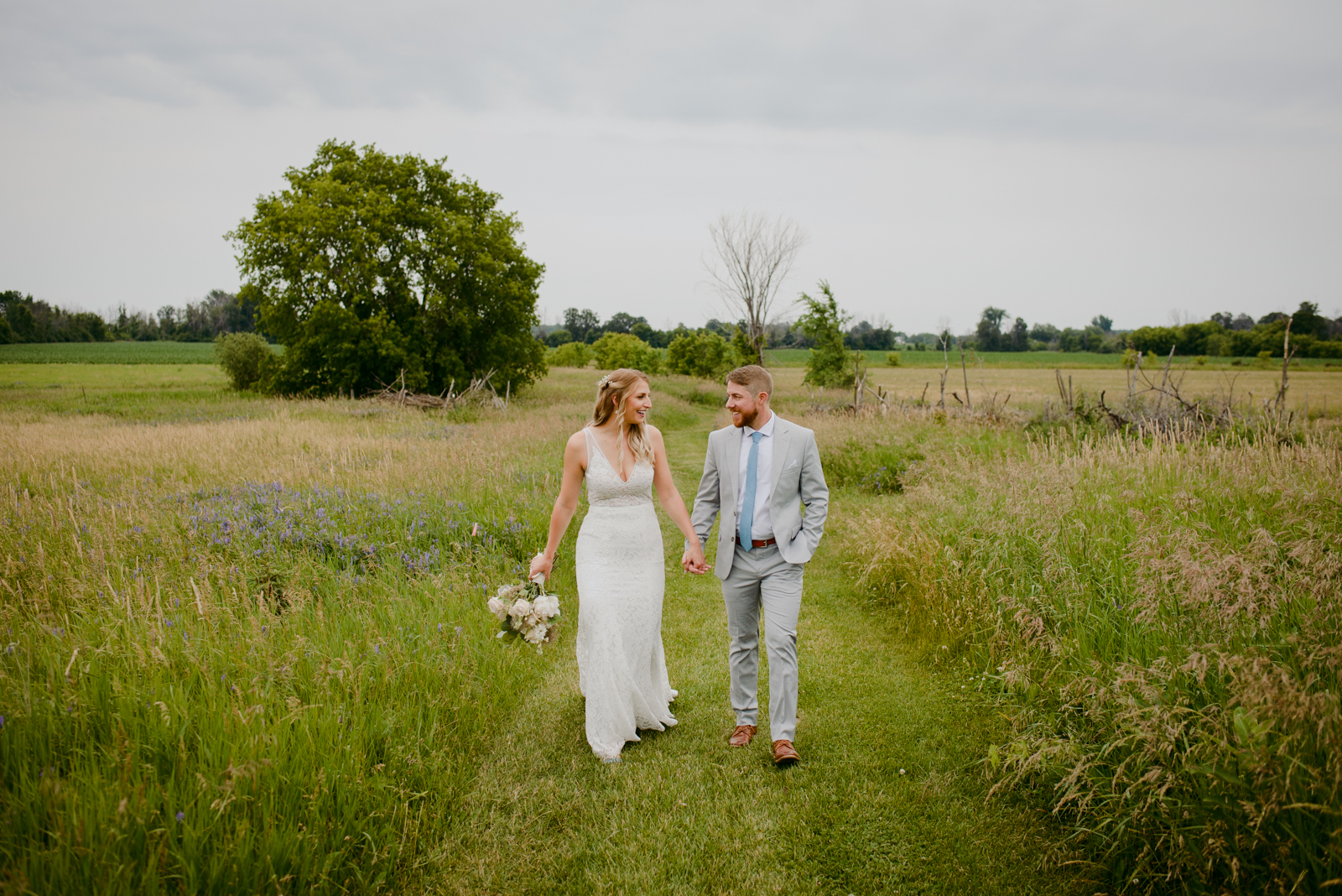 bride and groom walking through fields at Strathmere