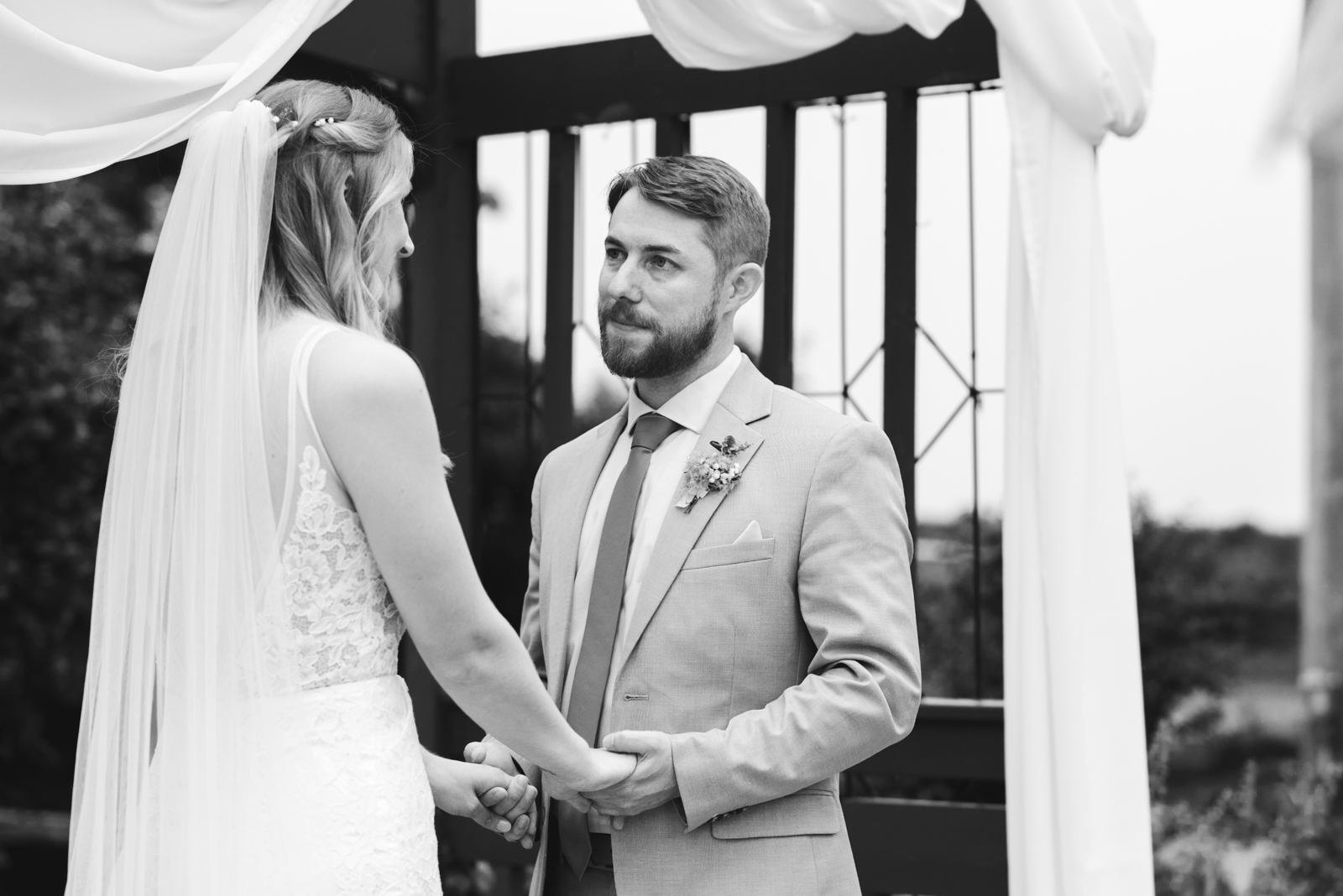 groom looking at bride as they say their wedding vows