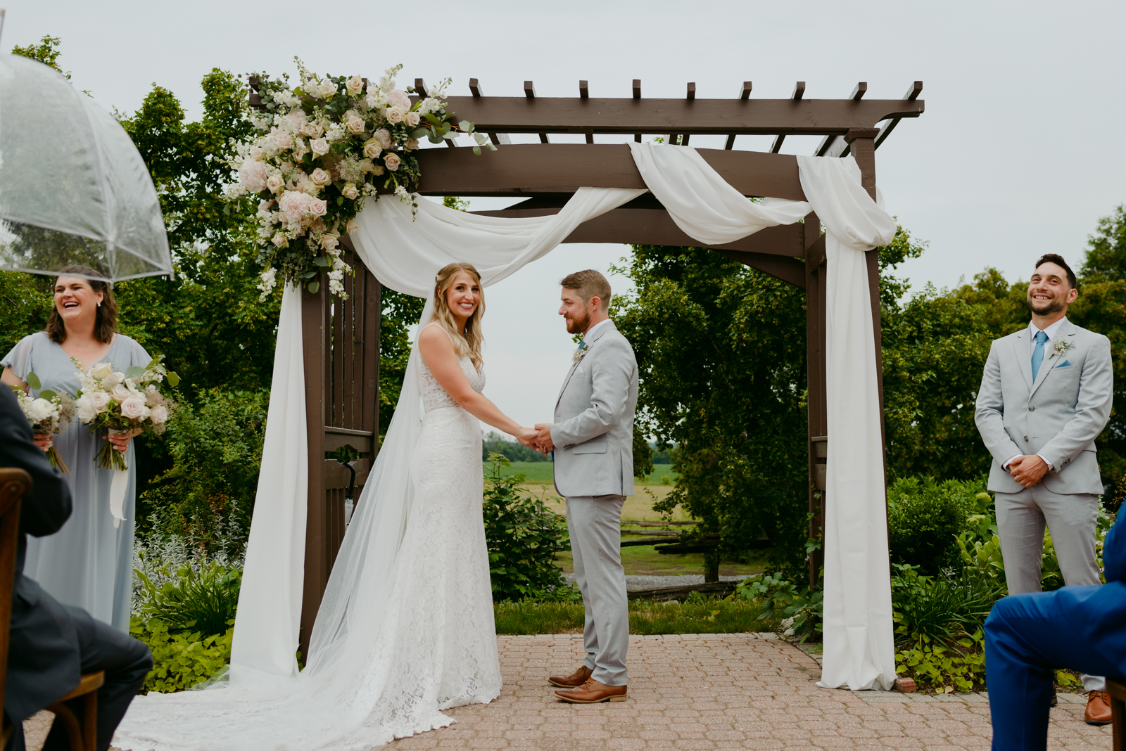 bride and groom under pergola wedding arch during outdoor wedding ceremony at Strathmere