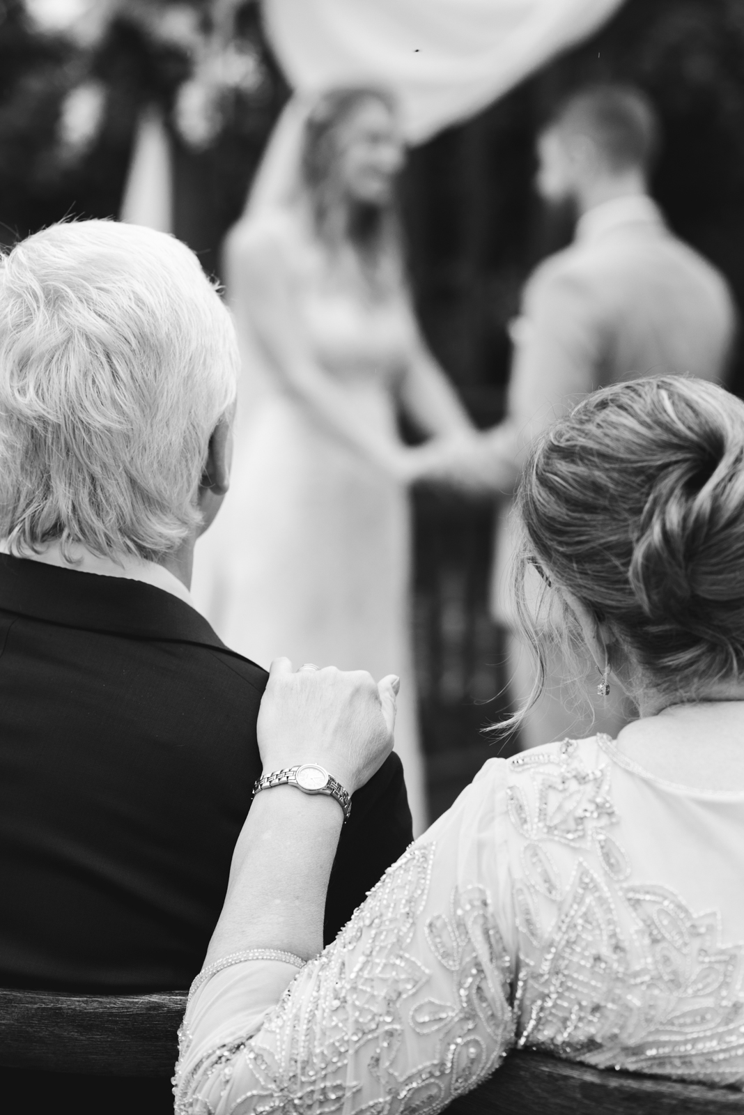bride's parents watching wedding ceremony in black and white
