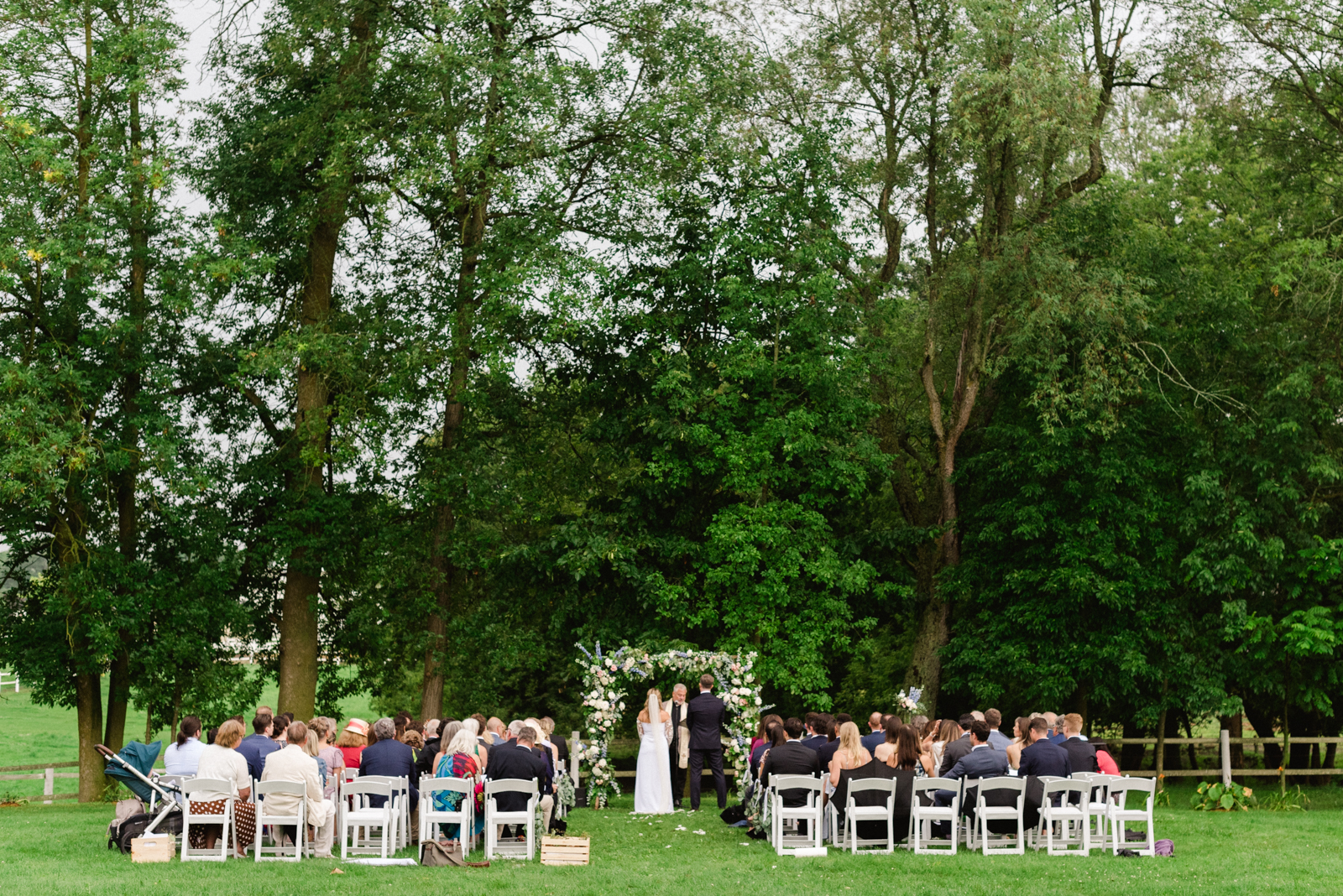 wedding ceremony at family farm under floral arch