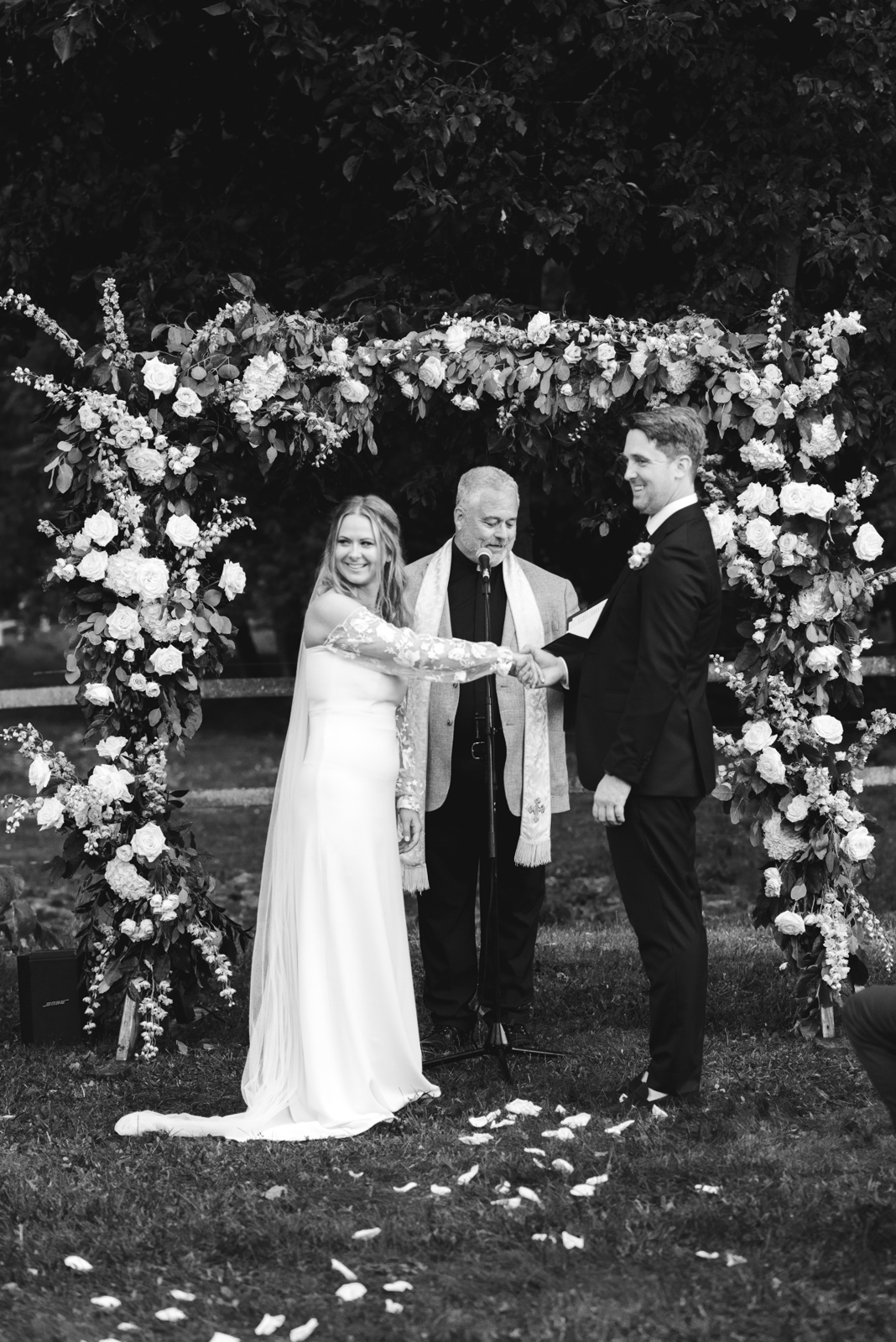 bride and groom under floral wedding arch