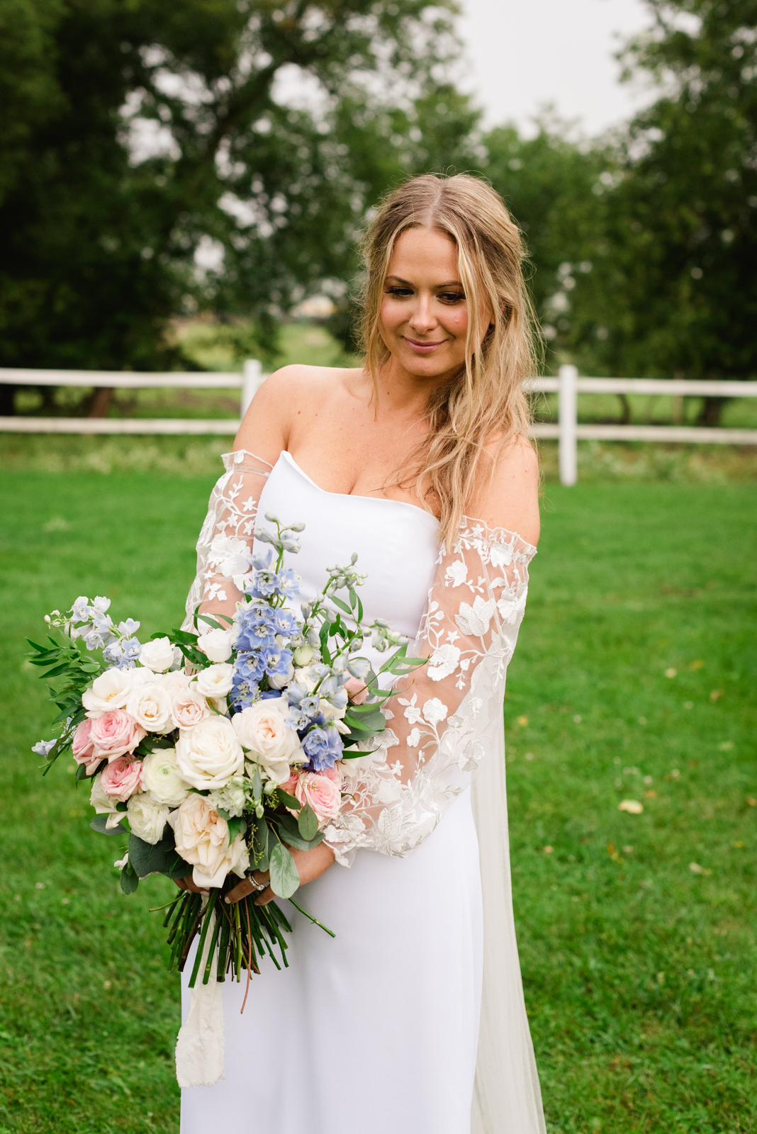 bride holding wedding bouquet in a field