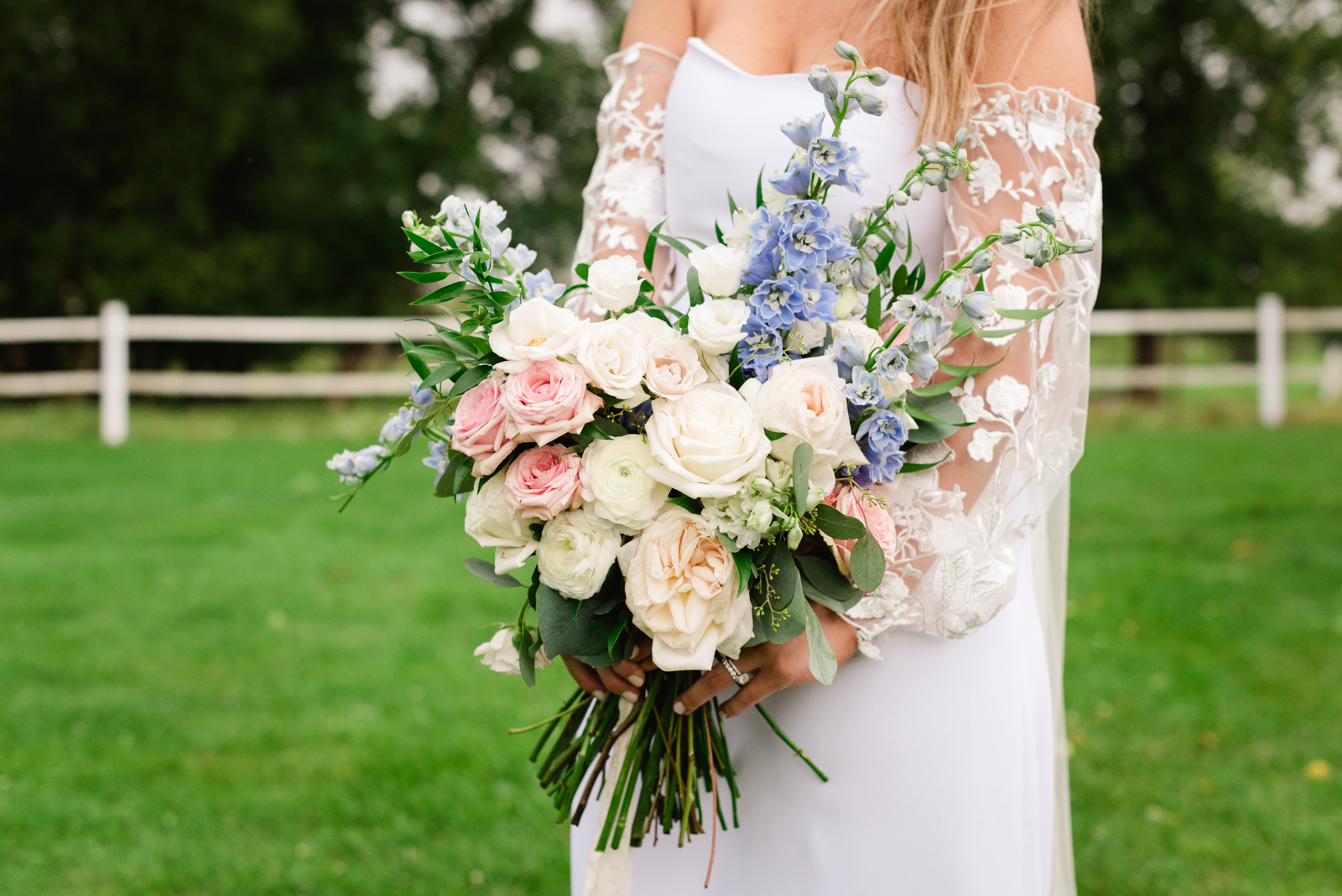 bride holding wedding bouquet in a field