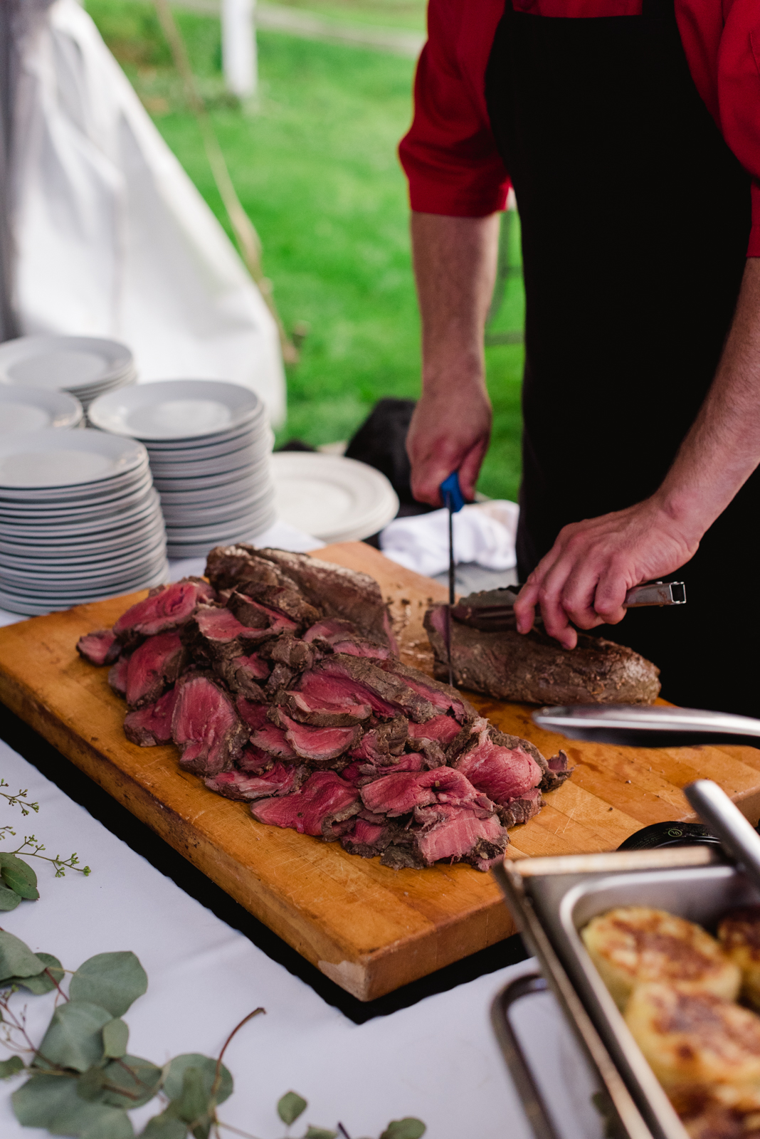 caterer slicing roast beef at wedding