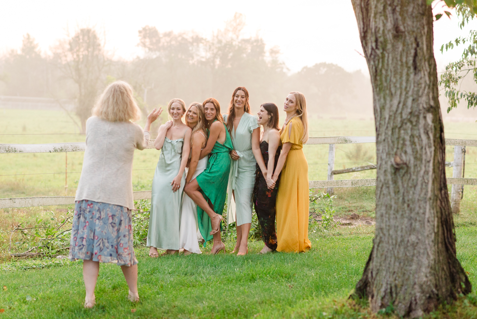 bride and her friends getting together for photo at sunset